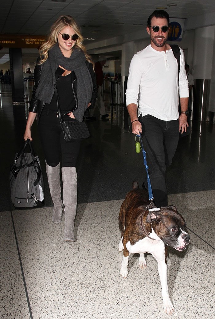 Kate Upton wears a leather jacket and a gray scarf as she catches a flight at LAX with her boyfriend Justin Verlander and their dog