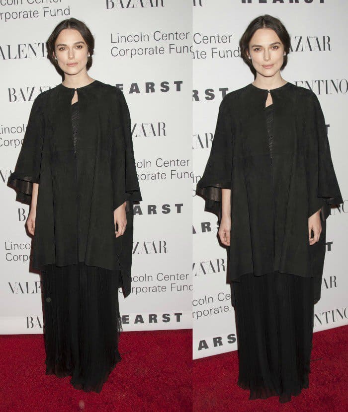Keira Knightley cloaked her frame in a flowing one-shoulder Valentino gown layered under a loose black suede cape, leaving her shoes hidden beneath the voluminous hem