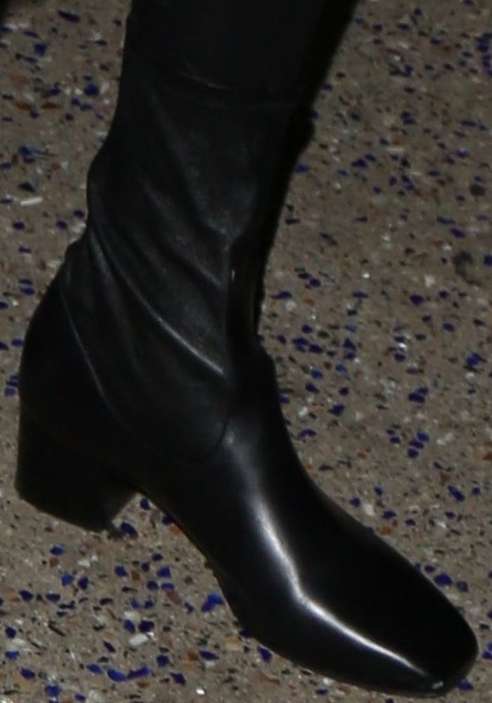 Kendall Jenner wears black leather Sandro boots featuring a square-toe and block heel