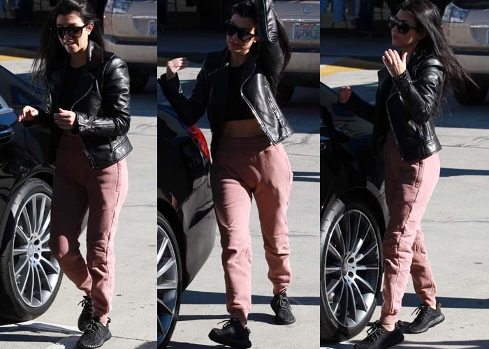 Kourtney Kardashian in a cropped top and pants by Yeezy, which she wore underneath a jacket from Balenciaga