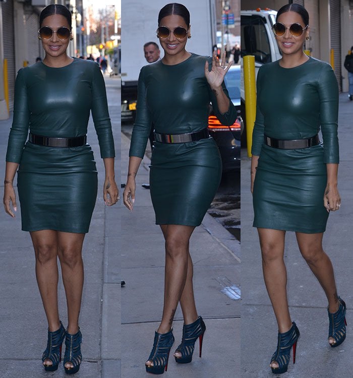 La La Anthony waves while wearing a skintight leather dress