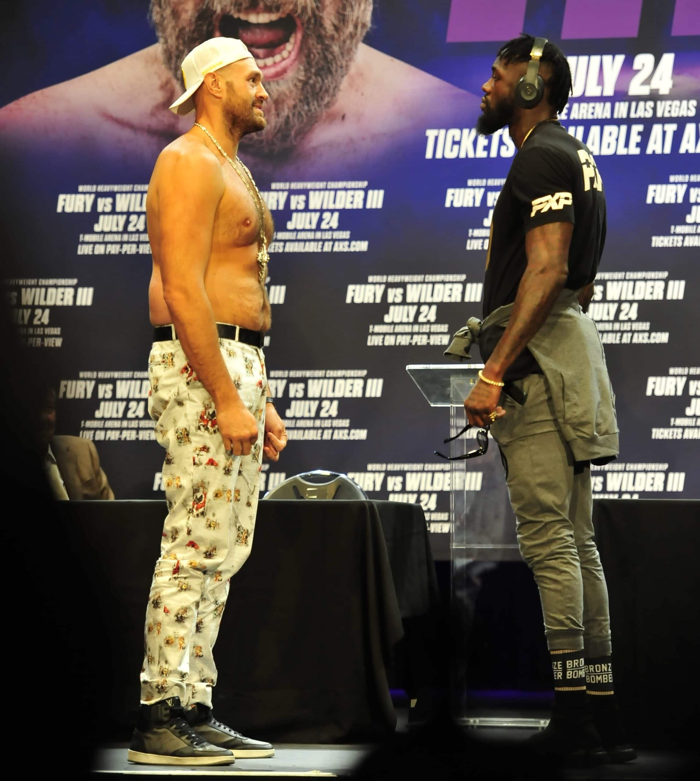 Tyson Fury compares his height to that of slightly shorter opponent Deontay Leshun Wilder at a press conference for the fight at the Novo theater in downtown Los Angeles