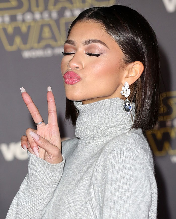 Zendaya shows off her rose-colored eyeshadow as she flashes a peace sign