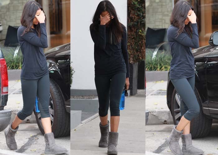 Zoe Saldana covers her face as she leaves her house