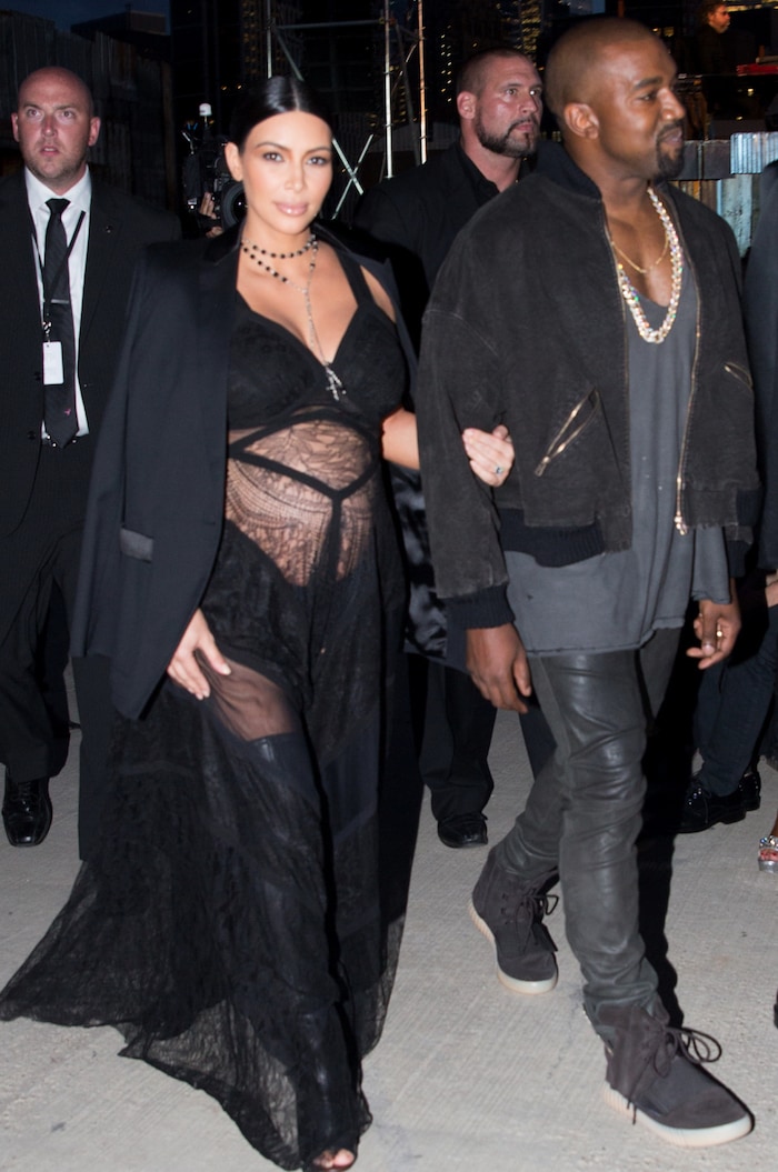 A pregnant Kim Kardashian wears a lingerie dress and thigh-high boots for the Givenchy Runway show at New York Fashion Week