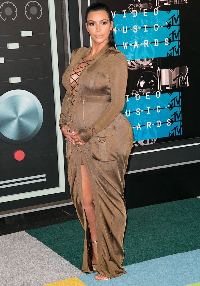 A pregnant Kim Kardashian attends the MTV Video Music Awards in a Balmain gown and Tom Ford sandals
