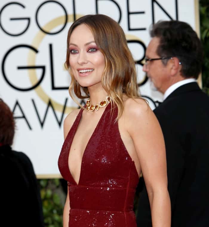 Olivia Wilde radiates in a close-up of her deep red Michael Kors Collection gown, accentuated by a bold gold necklace and matching eye makeup, at the 2016 Golden Globe Awards