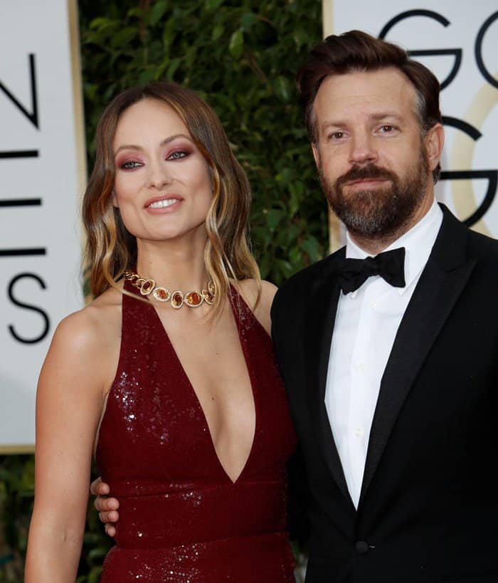 Olivia Wilde and Jason Sudeikis make a stylish pair on the red carpet, with Olivia shining in a deep red Michael Kors gown and statement gold necklace, at the 2016 Golden Globe Awards