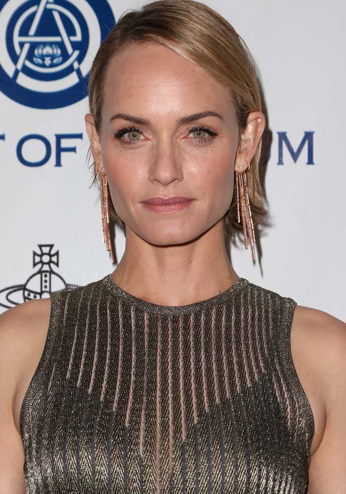 Former international fashion model Amber Valletta slicks her short hair back in a gold, sheer-stripe Vionnet Spring 2016 dress