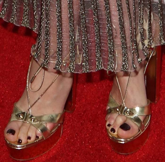 Amber Valletta's feet in gold platform Aquazzura sandals