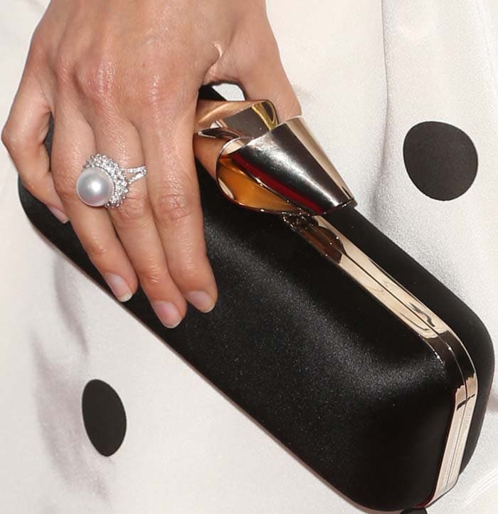 America Ferrera holds a black clutch on the red carpet