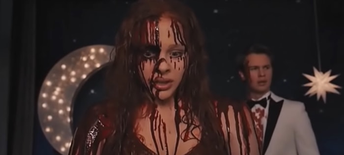 Chloë Grace Moretz in the iconic prom scene from Carrie (2013), covered in blood moments before unleashing her telekinetic powers