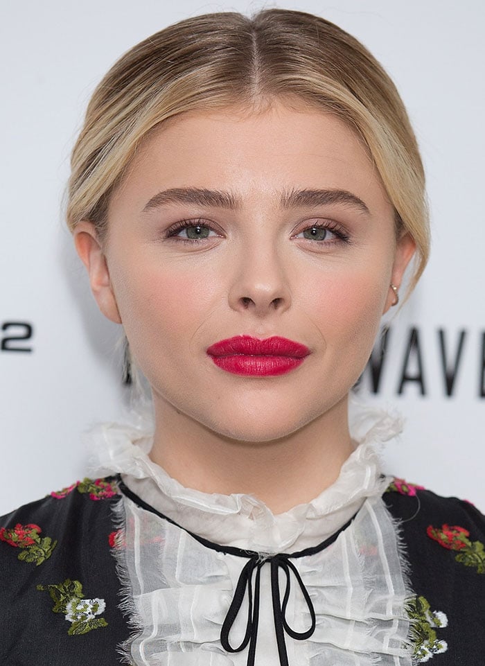 Chloe Grace Moretz center parts her hair for a photocall for "The 5th Wave"
