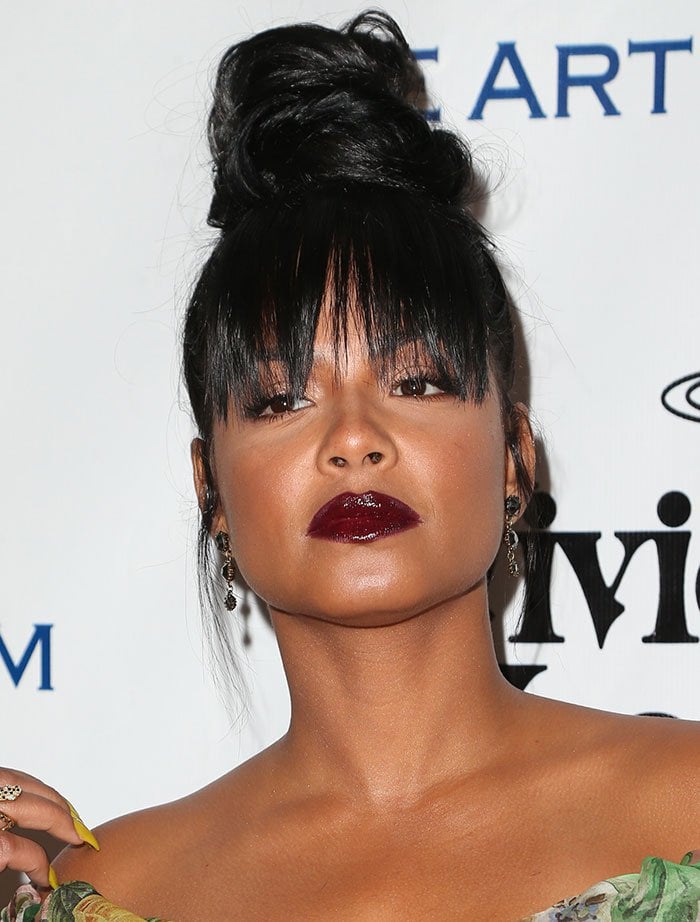 With her hair pulled up into a voluminous topknot, Christina Milian sported long bangs that cascaded over her eyes, adding a touch of mystery to her wild and adventurous appearance