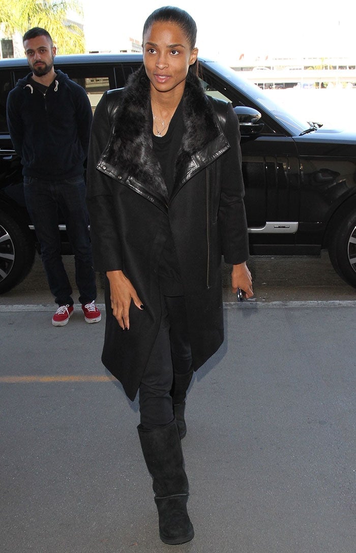 Ciara's all-black outfit comprised of a loose black top, pants, a coat, and Uggs