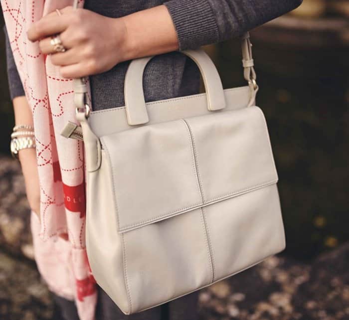 Elena's white handbag features an abundance of compartments