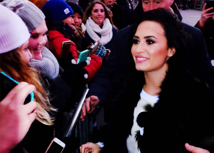 Demi Lovato wears a fur coat as she greets fans on New Year's Eve