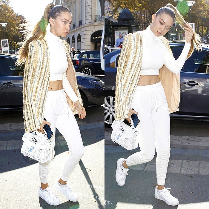 Gigi Hadid wears white sneakers at the Balmain show during the Paris Fashion Week