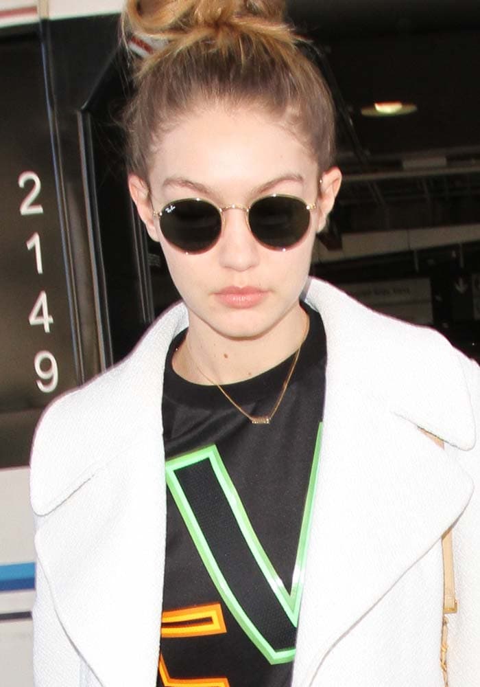 Gigi Hadid wears her hair up in an oversized mesh-paneled stretch-neoprene Versace sweatshirt