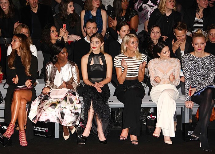 Gigi Hadid sits front row for a fashion show in a Sally LaPointe dress