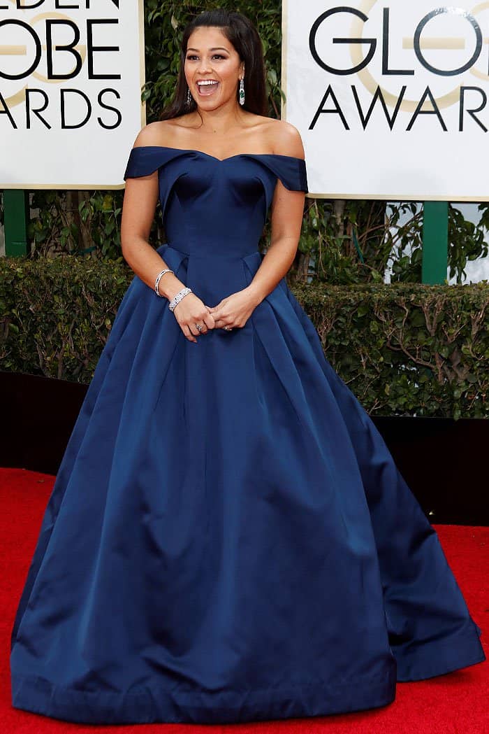 Gina Rodriguez wearing a navy off-the-shoulder gown by Zac Posen with pockets at the 73rd Golden Globe Awards