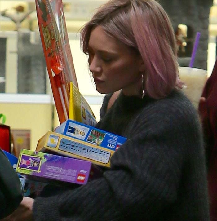 Hilary Duff carries a set of LEGOs and shows off her new pink hair