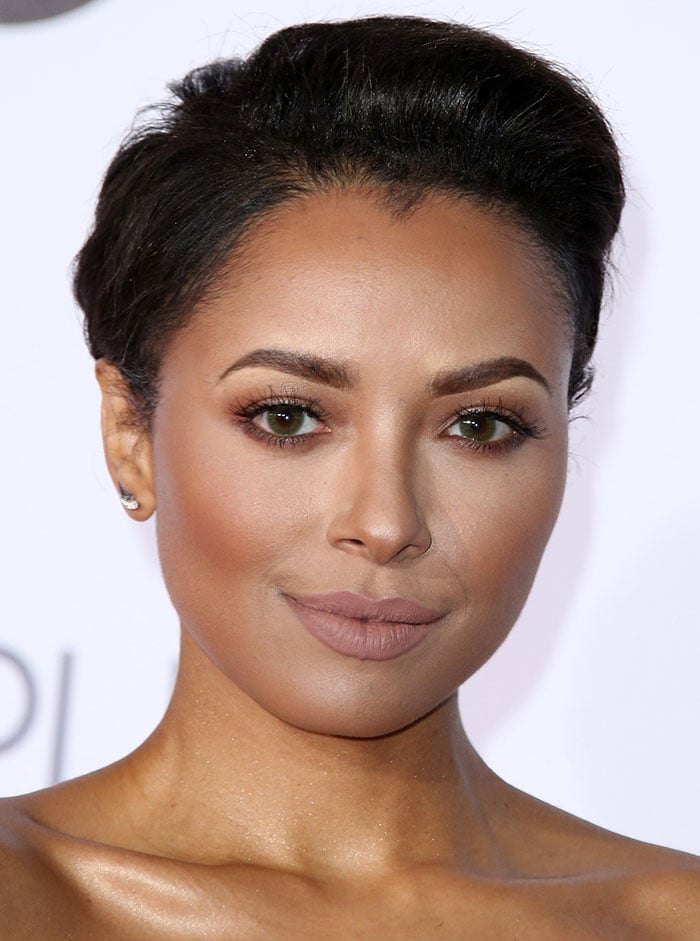 Kat Graham with brushed-back hair and muted makeup