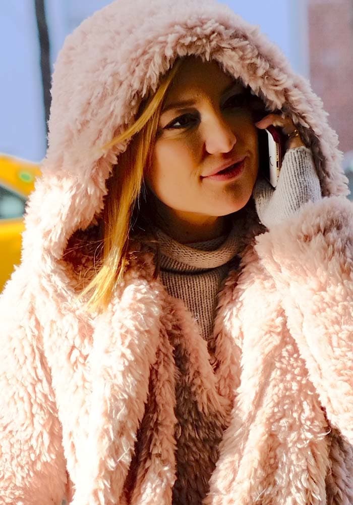 Kate Hudson covers her hair with a furry hood as she returns to her New York hotel