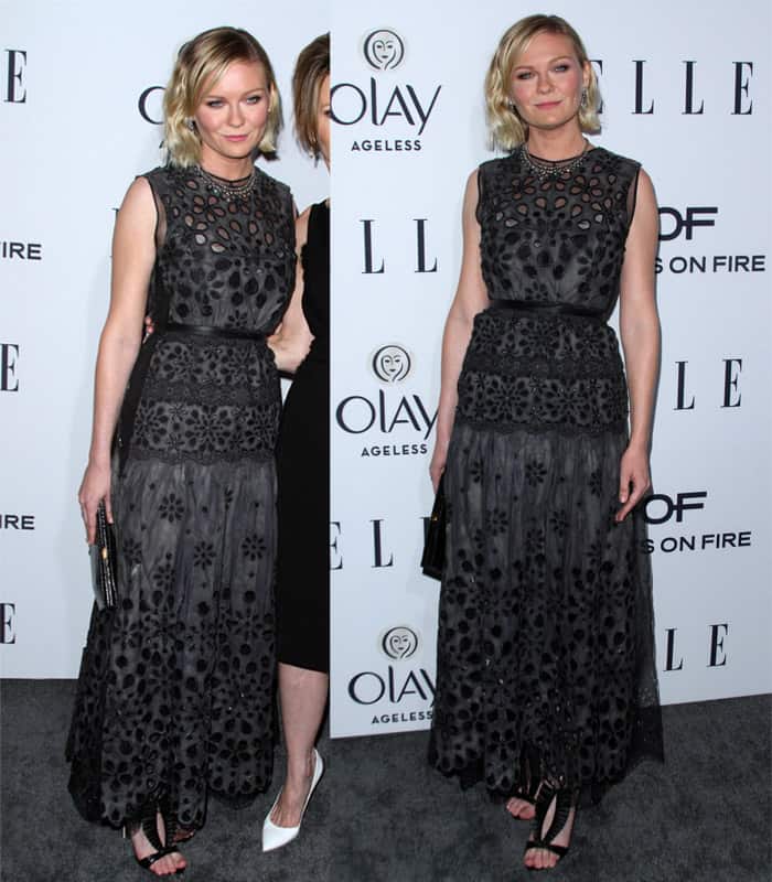 Kirsten Dunst in a sleeveless gray lace embroidered dress with a sheer underlay from Marc Jacobs' Resort 2016 collection, cinched at the waist with a skinny leather belt