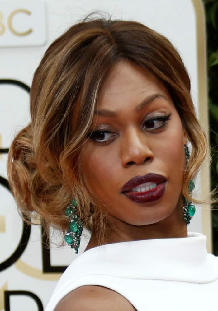 Laverne Cox captivates with her striking makeup and bold emerald earrings, adding a touch of glamour to her Golden Globe Awards appearance