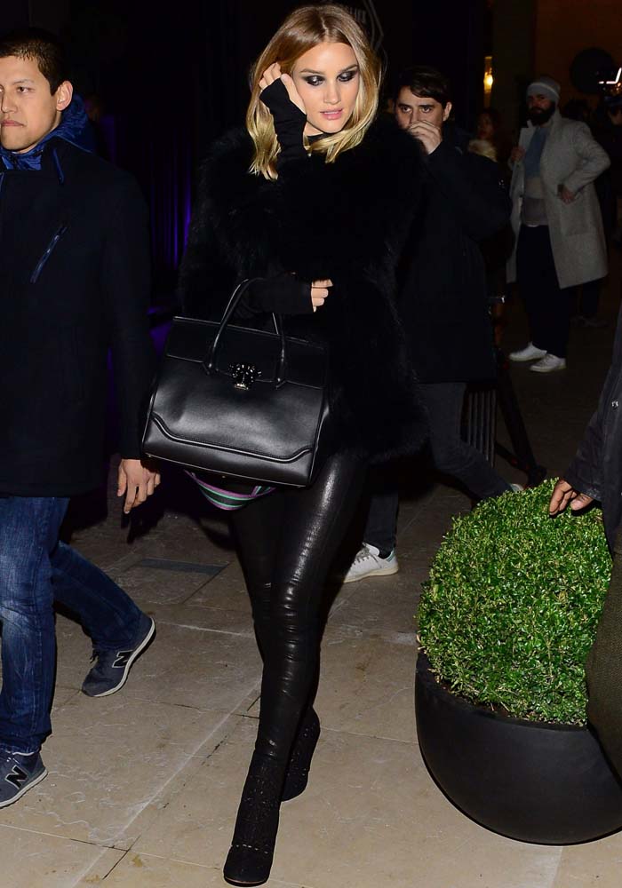 Rosie Huntington-Whiteley arrives backstage in a black sweater, fur jacket and leather leggings