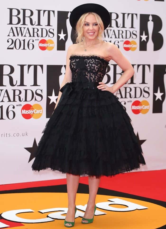 Kylie Minogue embraced playful vintage glamour at the 2016 Brit Awards in a strapless black lace Dolce & Gabbana dress, adding a pop of color with bold green satin peep-toe pumps that perfectly offset her voluminous tulle skirt