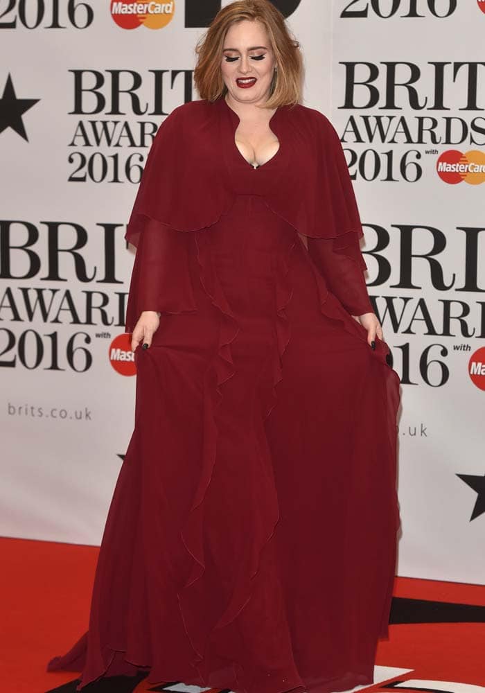 Adele wears a red floor-length Giambattista Valli dress at the BRIT Awards