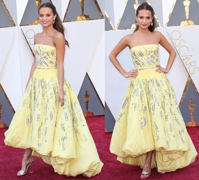 Alicia Vikander wears a voluminous yellow Louis Vuitton gown on the red carpet