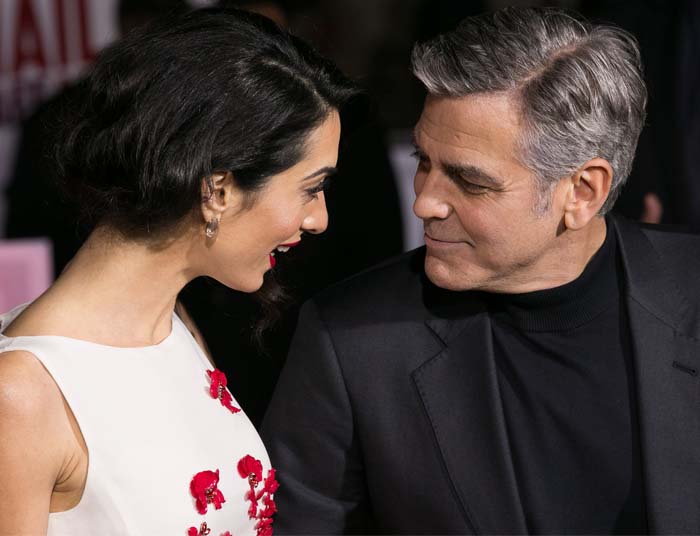 Amal Clooney and George Clooney pose for photos on the red carpet of the "Hey, Caesar!" premiere