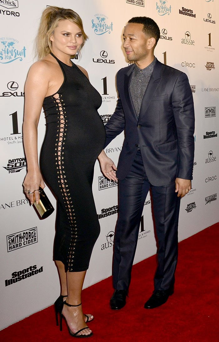 Chrissy Teigen wears a form-fitting black dress on the red carpet with husband John Legend