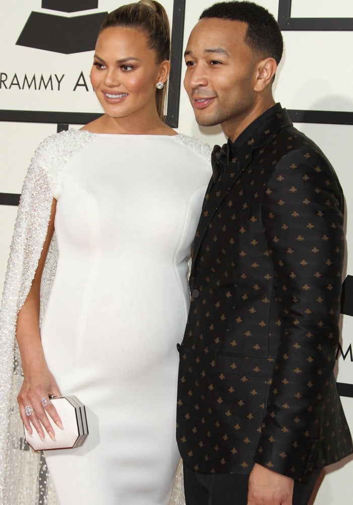Chrissy Teigen and John Legend pose for photos on the red carpet of the Grammys