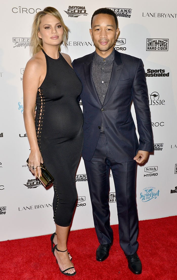 A pregnant Chrissy Teigen and husband John Legend pose for photos on the red carpet