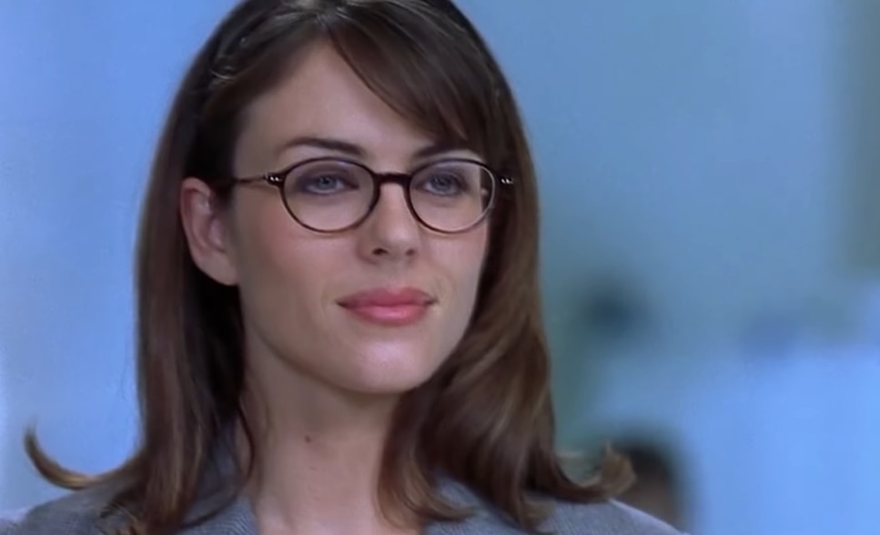 Elizabeth Hurley as Vanessa Kensington exudes intelligence and charm in a pair of stylish glasses in a scene from Austin Powers: International Man of Mystery