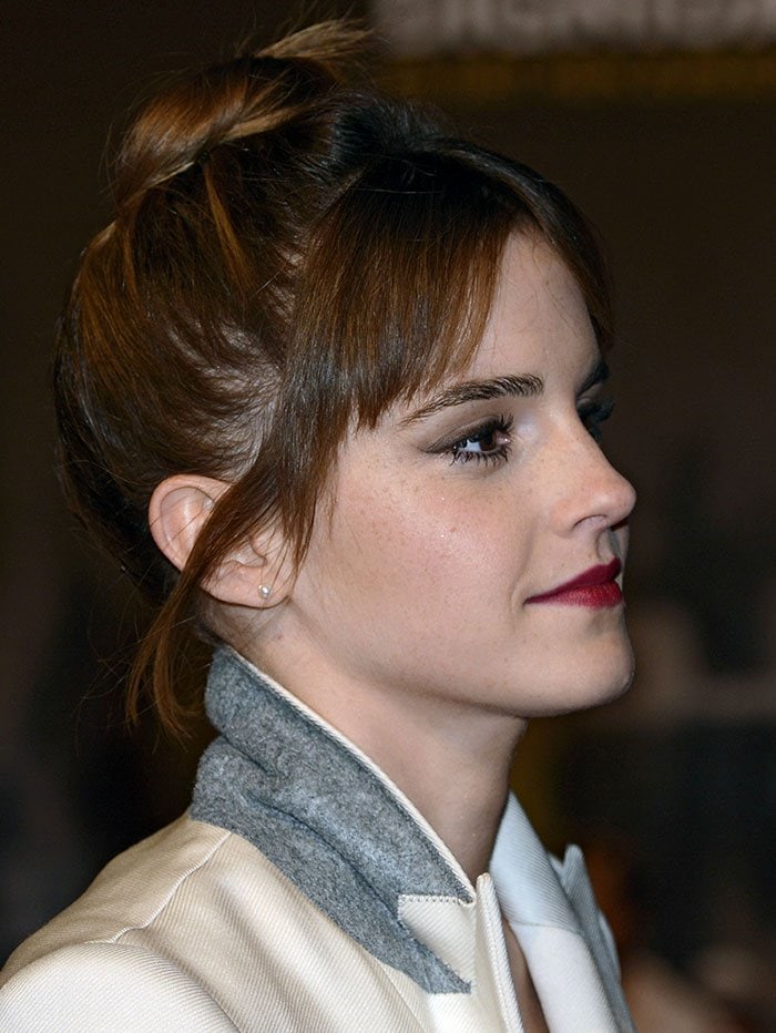 Emma Watson wears her hair in a loose updo as she poses for photos