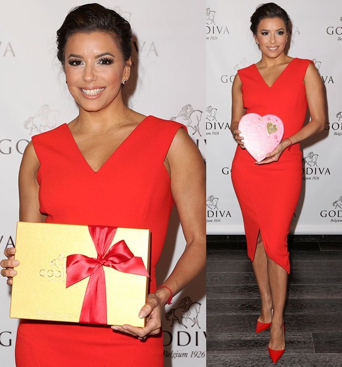 Eva Longoria poses with a box of Godiva chocolates in a red Victoria Beckham dress