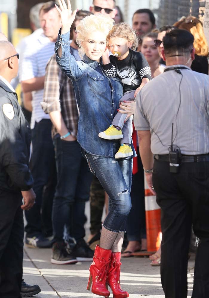 Carrying her son Apollo, Gwen Stefani gives the paparazzi and fans a quick wave