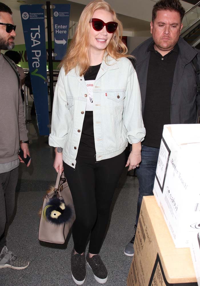 Iggy Azalea wears a Levi's jacket over a graphic t-shirt as she arrives at LAX