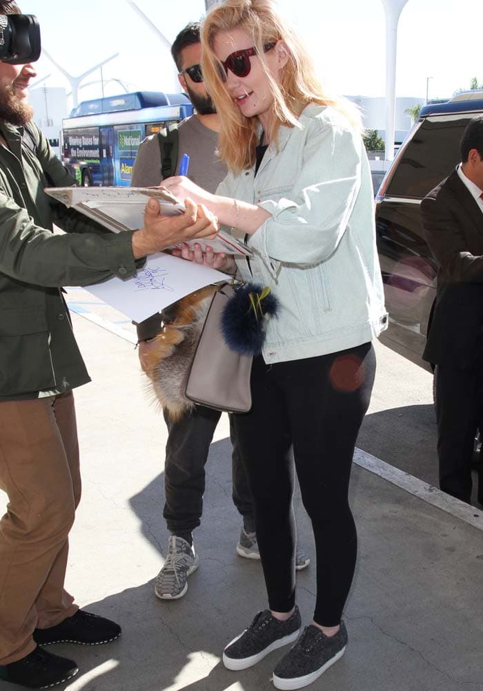 Iggy Azalea signs autographs for fans as she arrives at LAX