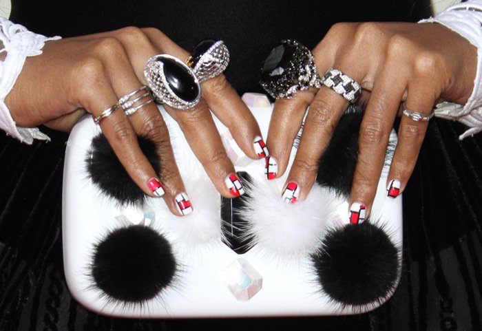 Janelle Monae shows off her Emm Kuo clutch and Carrera y Carrera and Levian rings at the Grammys