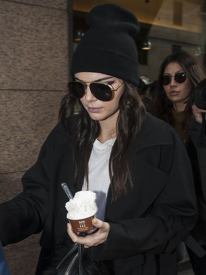Kendall Jenner carries a cup of ice cream as she leaves a fashion show
