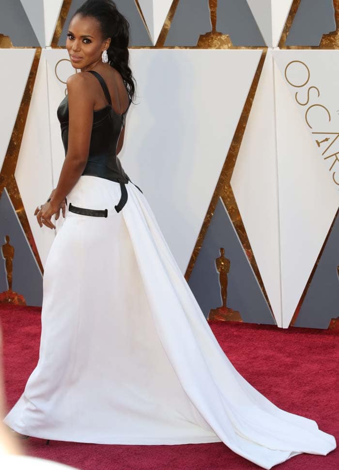 Kerry Washington shows off the dramatic train and contrasting leather bodice of her Atelier Versace gown, styling the look with statement Harry Winston diamond earrings and a sleek high ponytail