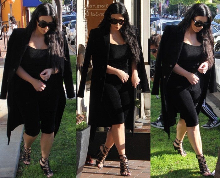 Kim Kardashian sported a monochrome ensemble consisting of a knee-length black bodysuit and a long coat