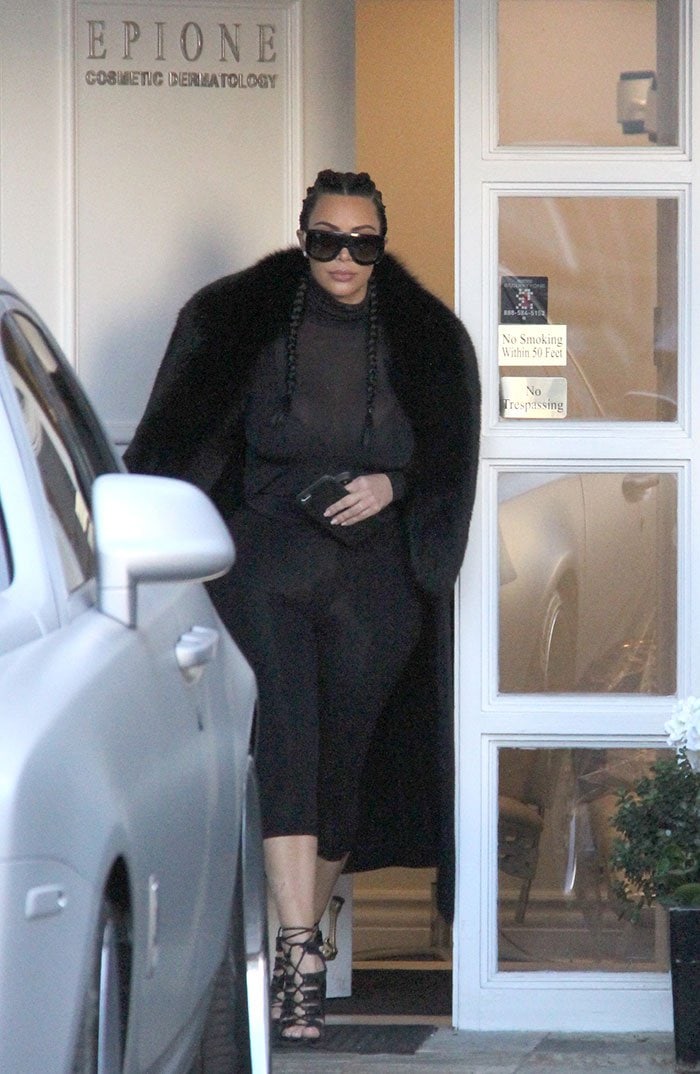 Kim Kardashian kept her accessories to a minimum with a pair of earrings and shielded her eyes behind a pair of Celine “Adele” sunnies