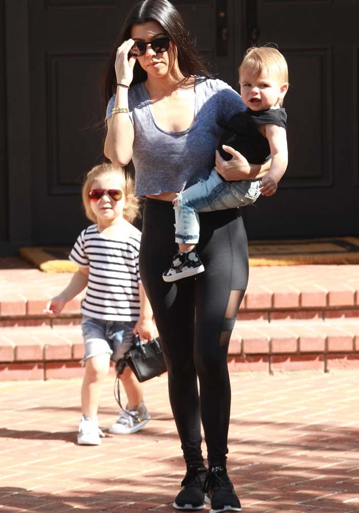 Kourtney Kardashian juggles her kids as she heads out for a hiking trip in Beyond Yoga leggings